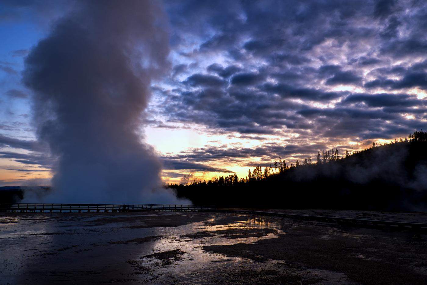 Geyser eruption silhouetted against a sunrise sky