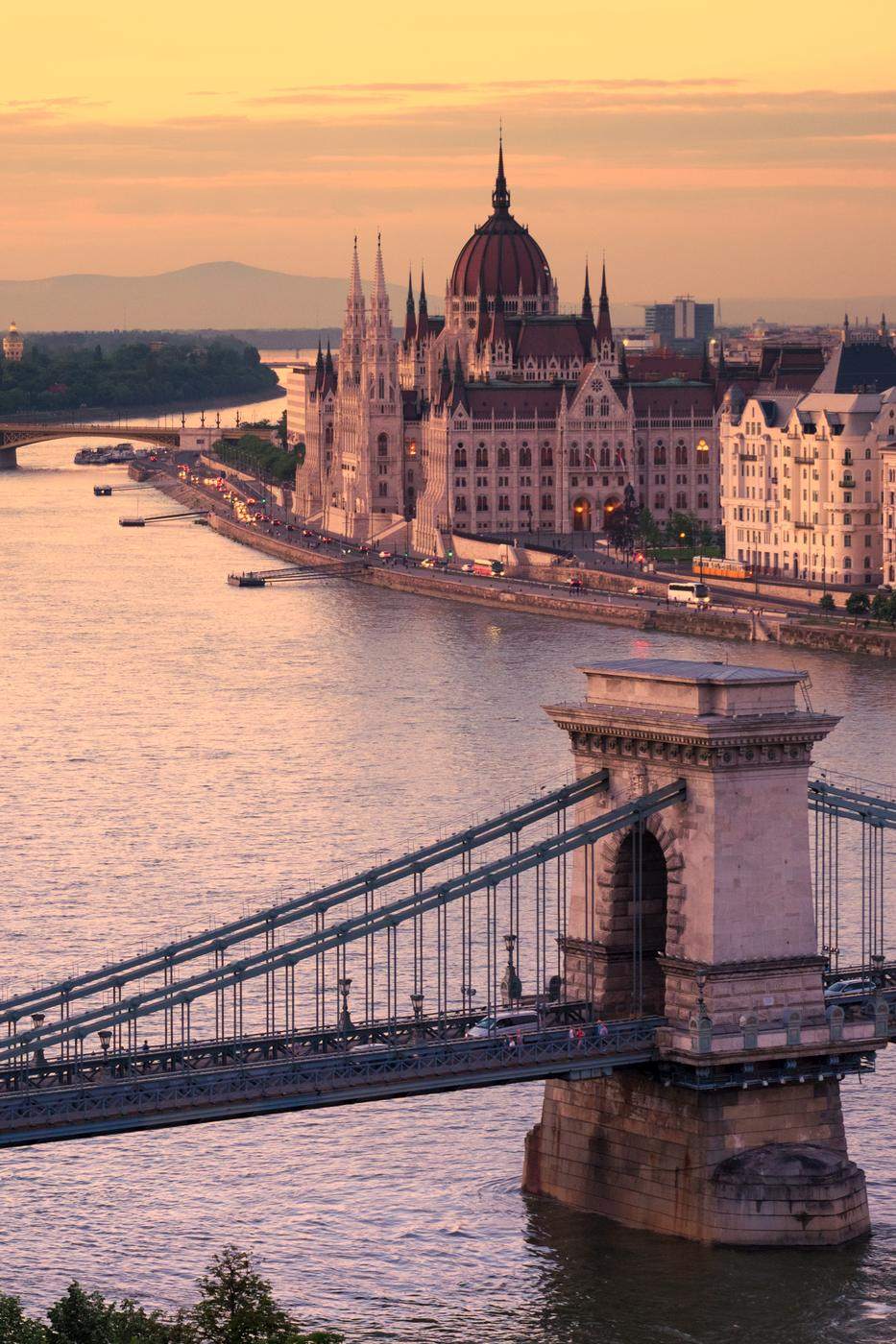 Parliament dome and bridge tower above the river at sunset