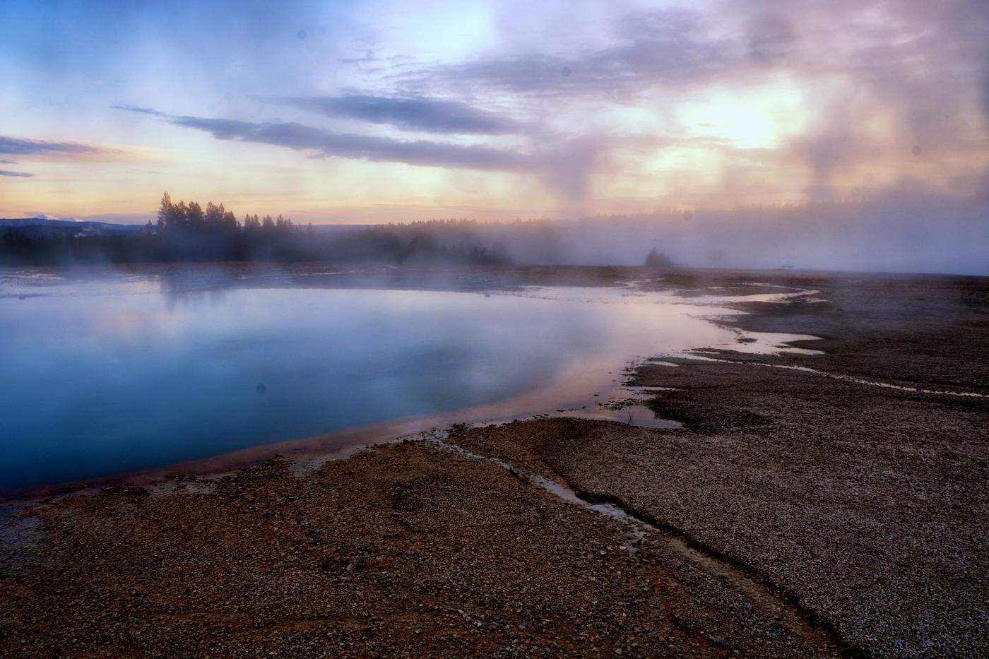 Mist over a turquoise hot spring at dusk in Yellowstone