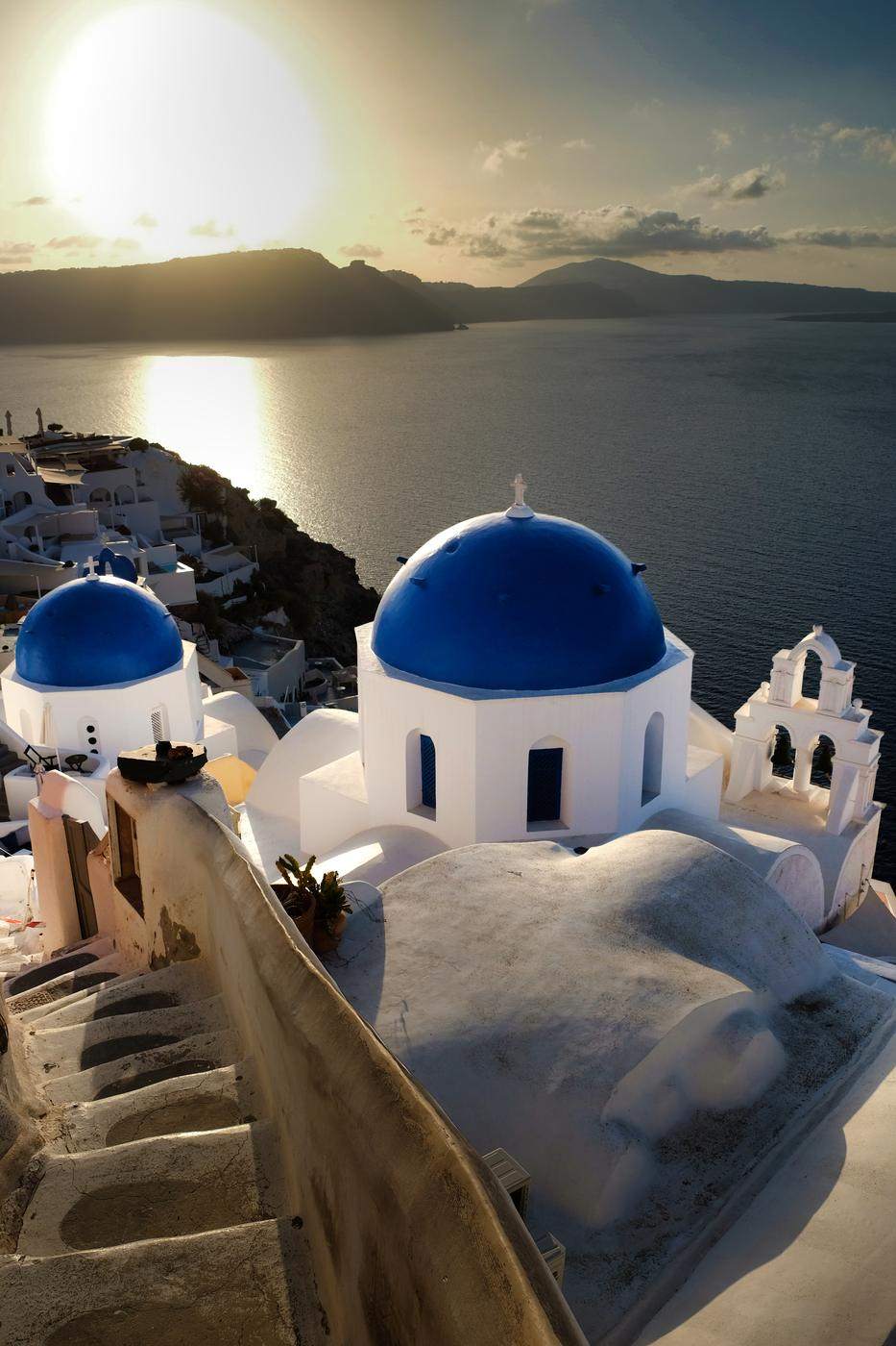 Two blue domes and whitewashed steps in late sun