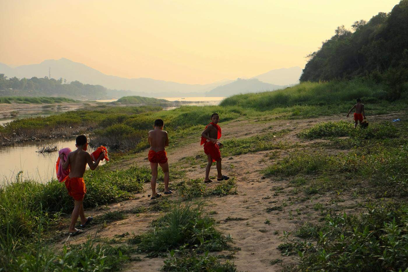 Young novices walking along a riverbank at golden hour